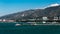 A motor yacht and a tug near the central pier of Gelendzhik against the backdrop of the Markotkh Mountains in the morning. Gelendz