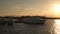 Motor yachts on the pier against the backdrop of the sun at sunset