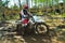 A motorbike cross racer is practicing on a muddy track