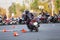 Motorbike driver riding bike on urban square using it as motordrome, rear view