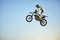 Motorbike, jump and person on blue sky mockup for training, competition and challenge with safety gear. Professional