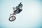 Motorbike, outdoor jump and man on blue sky mockup for speed challenge, sports risk and fearless skill. Driver, air