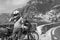 A motorbike traveler. poses black and white. incredibly beautiful view of Positano, a city on the edge of cliffs, the sea and a