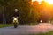 Motorbiker riding on empty road with sunset sky