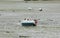 Motorboat on the muddy bottom of the sea at low tide in BRETANY