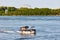 Motorboat sailing over the saint lawrence river with Saint Helen`s island and biosphere in the background  in Montreal, Quebec,