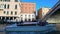 Motorboat with tourists sailing on canal in Venice, view on bridge and buildings