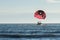 Motorboat towing a parasail parachute with a suspended person in