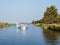 Motorboats cruising on canal in national park Alde Feanen, Friesland, Netherlands