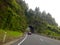 Motorcar driving on road tunnel carved out of rock mountain