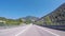 Motorcar moving on a highway near the railways against blue sky and Caucasian mountains. Scene. Sochi, Krasnodar region