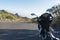 Motorcycle 125 parked in the roadside in a mountain road with curve. Naked motorbike from the behind in scenic asphalt and