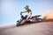 Motorcycle, athlete and sports outdoor, fitness and riding in desert with stunt for extreme sport, fast and safety