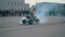 Motorcycle ATV hyped engine of his ATV and burning tires. The rear wheels are spinning in contact with the asphalt and from under