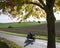 Motorcycle on country road and tractor with harrow on field in dutch province of south limburg