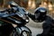 Motorcycle driver in leather suit and helmet sits in front of the motorcycle alone and put his hands on the headlights