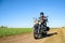 Motorcycle Driver Riding Custom Chopper Bike on Autumn Dirt Road in the Green Field. Adventure Concept.