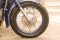 Motorcycle front wheel with shiny chrome knitting needles with blue rim close-up on the asphalt background