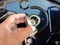 Motorcycle fuel oil tank cap in hand on cement floor background closeup