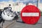 A motorcycle helmet hangs on the handlebars of a parked motorcycle against the background of a no entry sign, collage