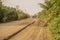 Motorcycle overtaking old trucks loaded with sawit palms seen on a dusty bumpy road near to Bengkulu, Sumatra, Indonesia