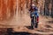 motorcycle racer on an enduro sports motorcycle rides fast on a dusty road in the forest in an off-road race