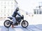 Motorcycle rider on custom made scrambler style cafe racer in th