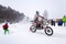 Motorcycle skijoring racers ride on snowy track