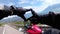 Motorcycle Travel. Gloved Hands of a Biker Show a Photograph Sign on Lake Geneva and Swiss Alps