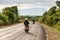 Motorcycle travels on the National Highway T 16 from Salavan to Pakse. Asphalt road on Bolaven Plateau at evening, Laos people