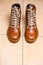 Motorcycling Relative Topics. Closeup of Protective Motorcyclist Leather Tan Sneakers Placed Indoors On Pale Tiles Floor