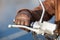 Motorcyclist arm in brown leather glove holds twist grip throttle, close up view