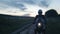 Motorcyclist biker rides a motorcycle. Rides on a country road against the background of sunset. Travel alone