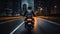 Motorcyclist in a black jacket on a black bike rides along a deserted night road