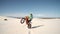 Motorcyclist doing wheelis on his bike across sand dunes