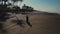 Motorcyclist is driving over empty beach, aerial shot