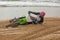 Motorcyclist fell on a motorcycle on the beach against the backdrop of the sea