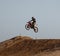 Motorcyclist jumping with his motorcycle in the air captured doing stunt in motocross race