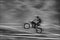 The motorcyclist is landing. A moving blur background. B/w