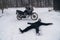 A motorcyclist is lying on a snowy road, a fall, an incident due to a slippery surface. It is impossible to move under such