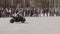 The motorcyclist makes steep turns and drifts in the city square in front of the audience.