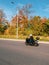 Motorcyclist in motion. Biker on a black motorcycle in traffic on a rural autumn road