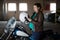Motorcyclist pregnant woman preparing to ride chopper bike, put on helmet at parking lot