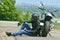 Motorcyclist rests near his motorbike