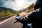 A motorcyclist rides a bike on a road in a mountainous area. Generative AI