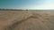 Motorcyclist riding along sandy beach. Biker rides motorcycle through desert.