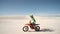 Motorcyclist riding his bike across sand dunes