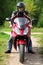 Motorcyclist standing on country road