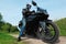 Motorcyclist standing on country road, bottom view