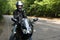 Motorcyclist standing on road